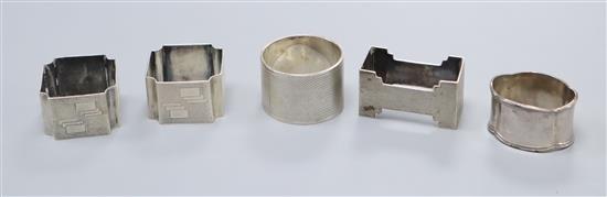 A pair of George V Art Deco silver napkin rings by Walker & Hall, Sheffield, 1935 and three other silver napkin rings.